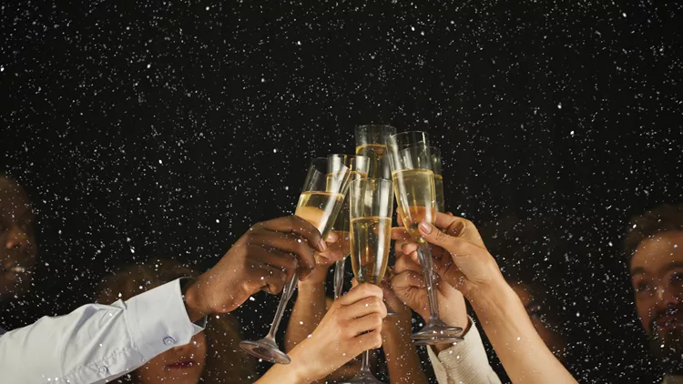 Group of young people celebrating new year with champagne at night club